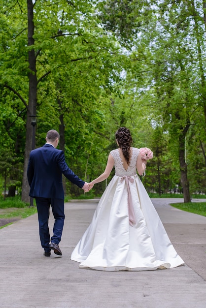 Bride and groom with wedding bouquet in the park