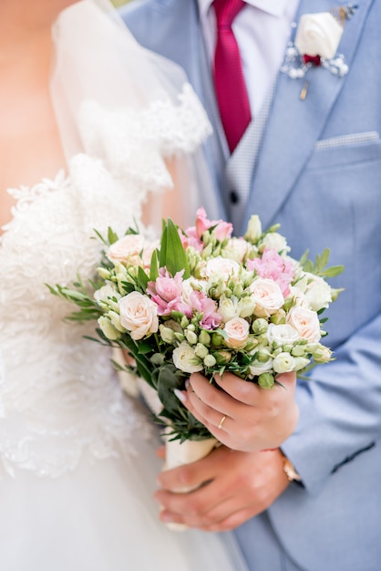 Sposa e sposo con bouquet da sposa