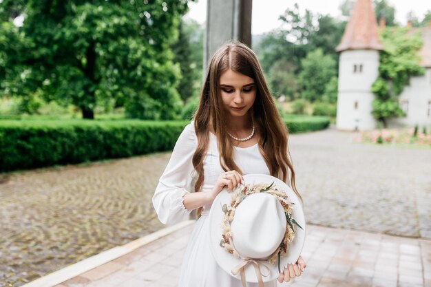 The bride in a hat and a bouquet portrait of a bride in a white
dress portrait of the bride young girl in a white wedding dress and
hat with a bouquet of flowers