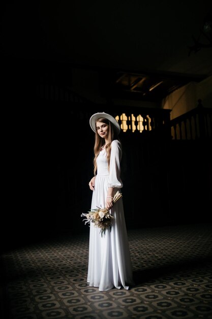 The bride in a hat and a bouquet portrait of a bride in a white
dress portrait of the bride young girl in a white wedding dress and
hat with a bouquet of flowers