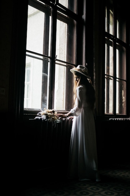 The bride in a hat and a bouquet portrait of a bride in a white
dress portrait of the bride young girl in a white wedding dress and
hat with a bouquet of flowers