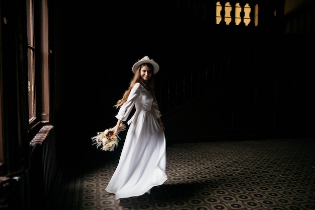 The bride in a hat and a bouquet portrait of a bride in a white\
dress portrait of the bride young girl in a white wedding dress and\
hat with a bouquet of flowers