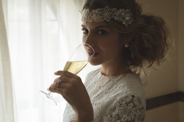 Bride having a glass of champagne at home