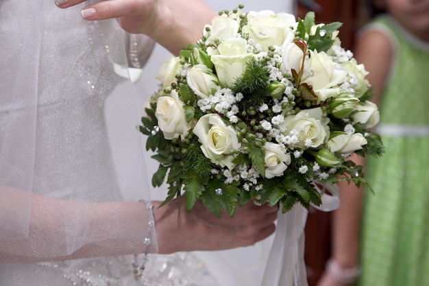 bride hoding beautiful wedding bouquet of white roses