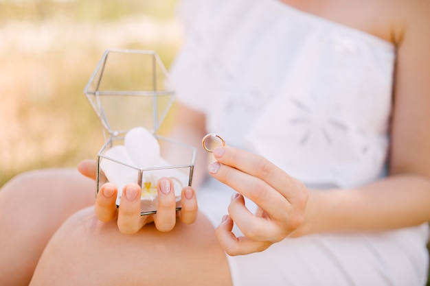 花嫁は結婚指輪と宝石箱を手に持っています。