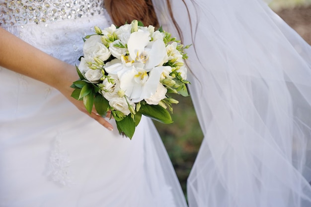 Sposa che tiene un bel bouquet bianco