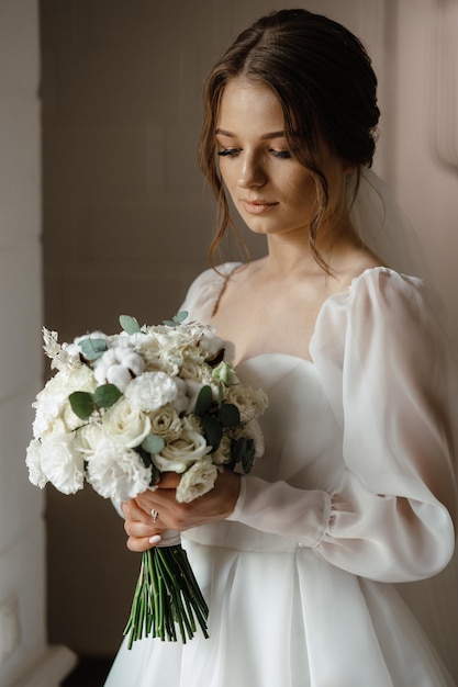 Bride holding a bouquet of flowers in a hotel room