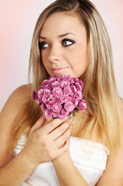 Bride holding a bouquet of pink chrysanthemums