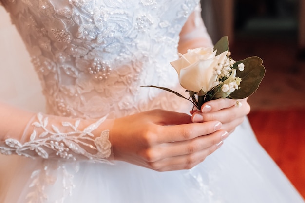 bride holding a boutonniere in her hand