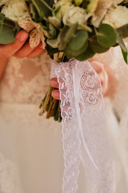 Bride holding a bright wedding bouquet with different flowers