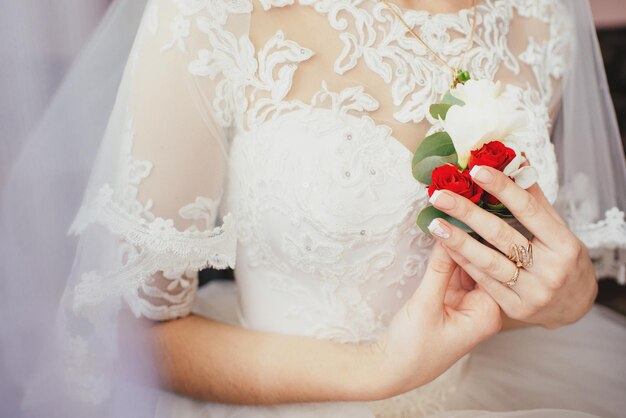 A bride holding buttonhole