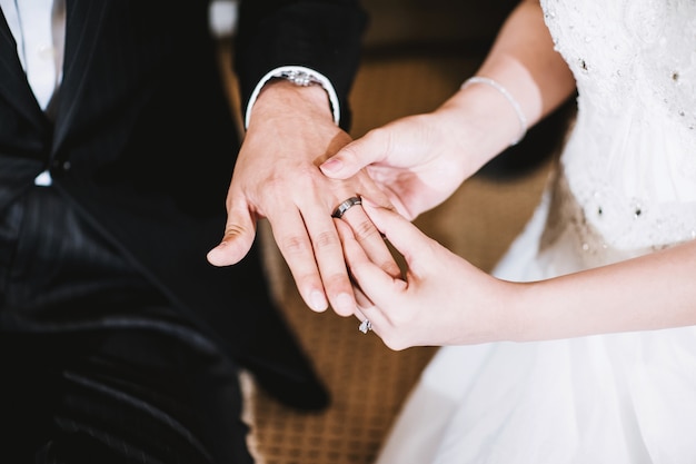 The bride holding the handof the groom showing wedding couple rings