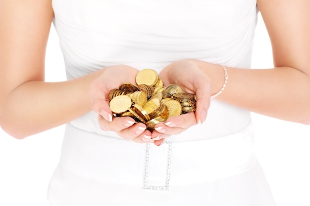 Bride holding in hands gold coins over white background