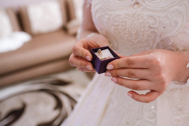 Bride holding little box with earrings closeup