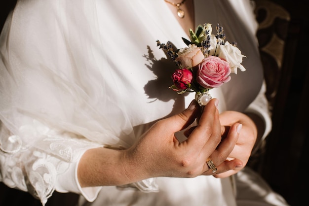 Bride holding tiny buttohole in hands closeup