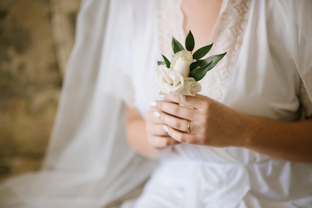 A bride holding tiny buttohole in her hands