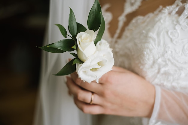 A bride holding tiny buttohole in her hands