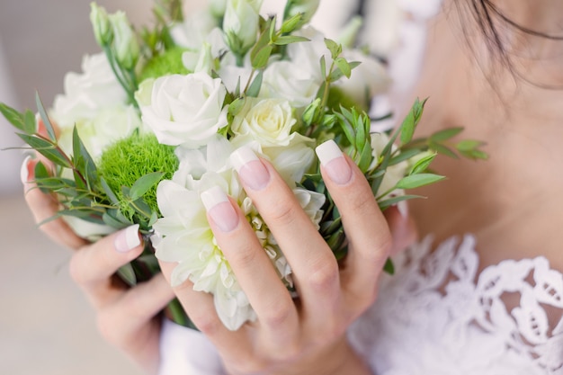 The bride holding a wedding bouquet by hands