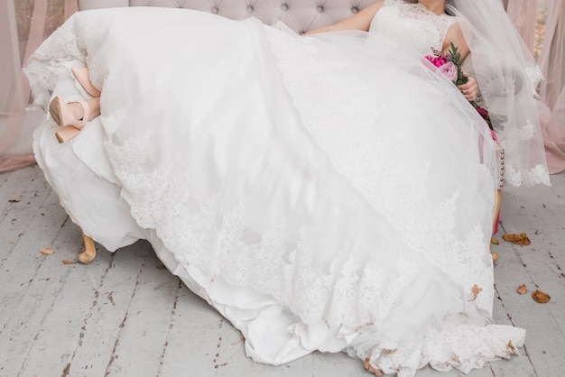Невеста держит свадебный букет в платье