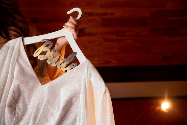 Photo bride holding wedding dress with inscription 