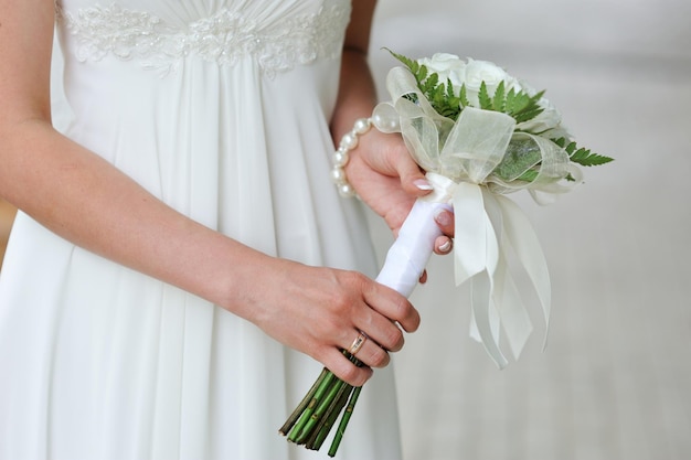 Bride holding wedding flower bouquet of white roses