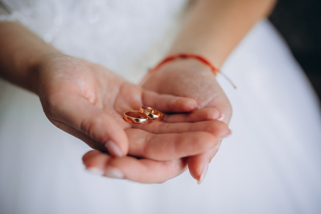 Bride holding wedding rings on her wedding day