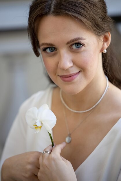 Bride holding white orchid flower