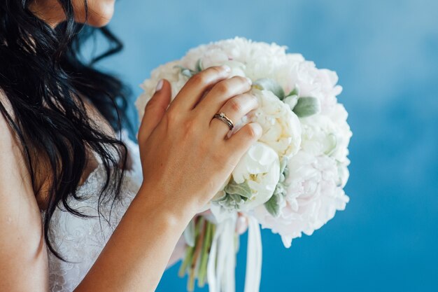 Bride holding white wedding bouquet of roses and love flower.