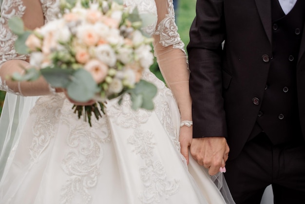 The bride holds a beautiful bouquet of white flowers Closeup view