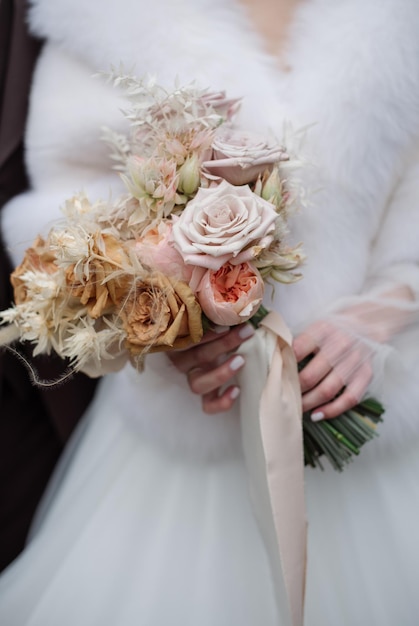 The bride holds a beautiful bouquet of white flowers Closeup view