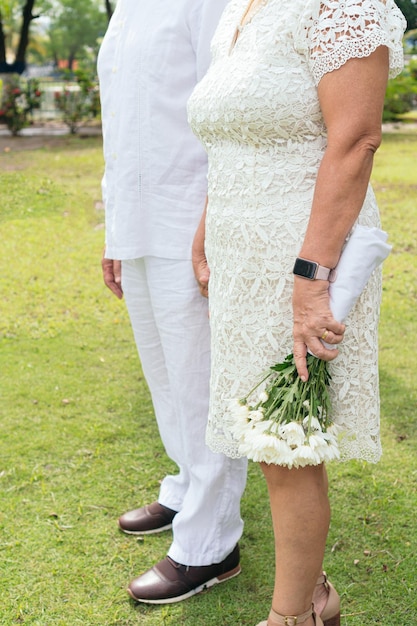 신부는 결혼식 날 아름다운 하얀 꽃 꽃다발을 들고 있는 신혼부부들