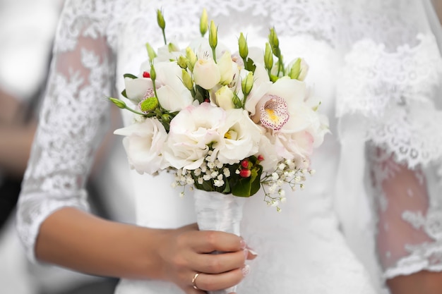 The bride holds the beautiful wedding bouquet