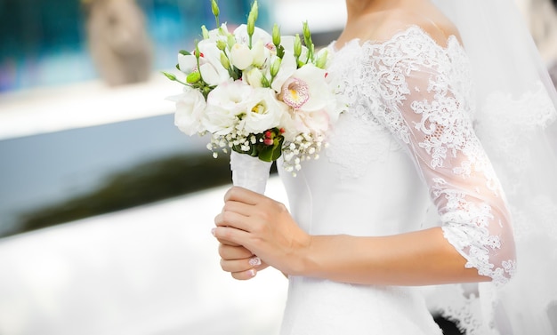 The bride holds the beautiful wedding bouquet
