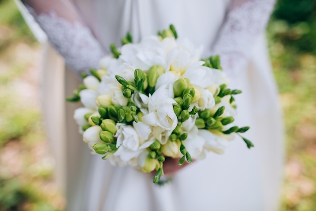 The bride holds a beautiful white wedding bouquet