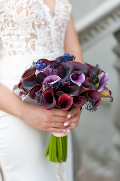 La sposa tiene un bouquet di calle viola scuro.