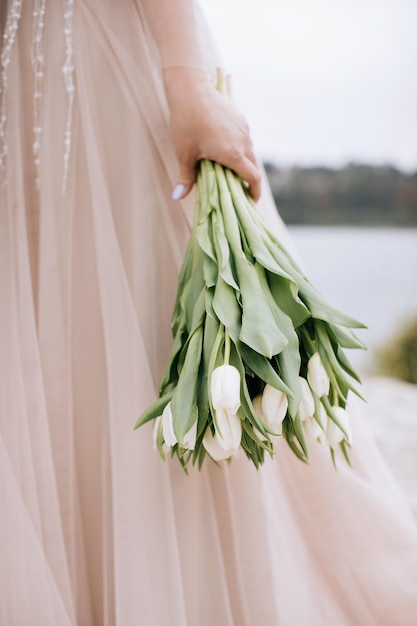 The bride holds a bouquet of white tulips Gift for the bride