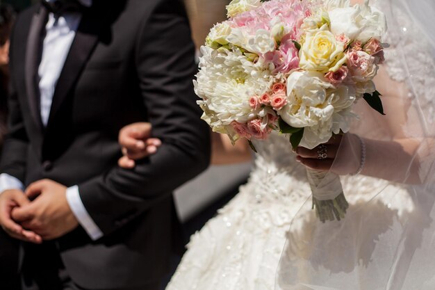 花嫁は花婿の腕を持っています。結婚式、花嫁は花婿の腕を持っています