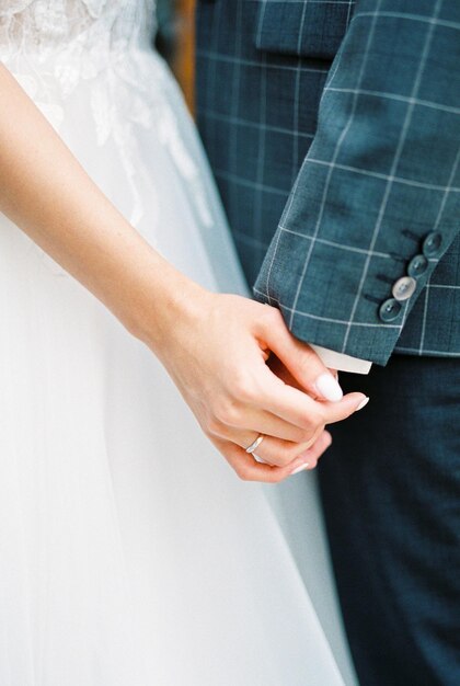 Bride holds groom hand Closeup