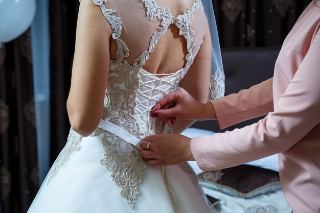 The bride holds in her hands a beautiful wedding dress