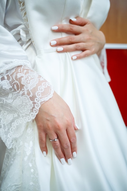 The bride holds in her hands a beautiful wedding dress