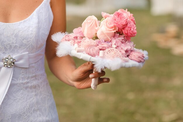 The bride holds her wedding bouquet in her hands