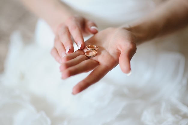 Bride holds on the palm two gold rings