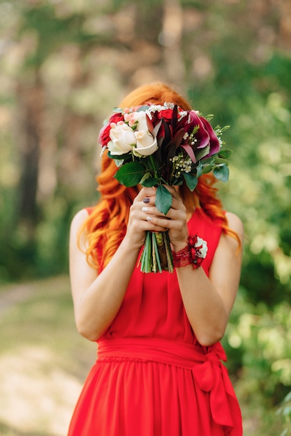 The bride holds a wedding bouquet in her hands