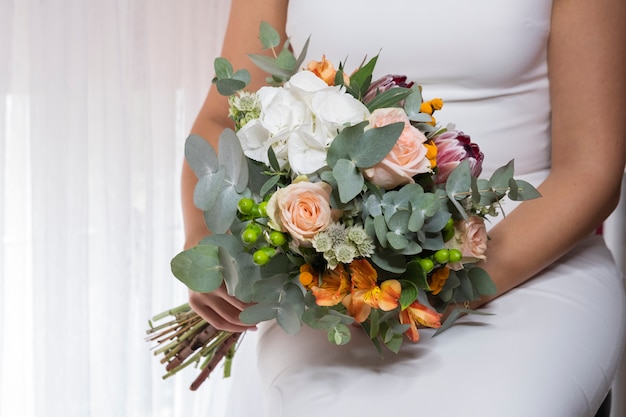 写真 花嫁は結婚式の祭典でさまざまな色のウェディングブーケを開催