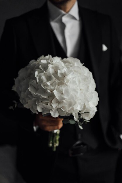 花嫁は結婚式の花束のウェディングドレスの結婚式の詳細を保持します