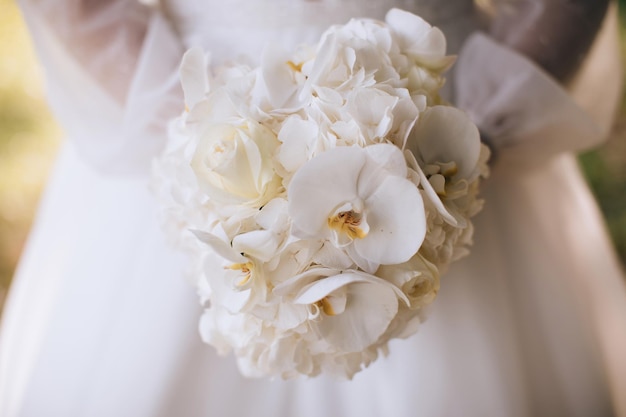 The bride holds a wedding bouquet of white orchids Wedding decor ideas