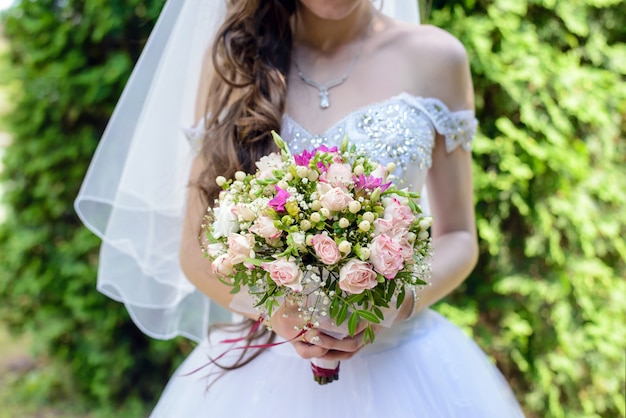 The bride holds a wedding bouquet