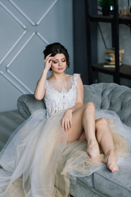 La sposa è una bruna dall'aspetto europeo, ritratto unico. trucco e acconciatura da sposa. mattina della sposa. boudoir in hotel.