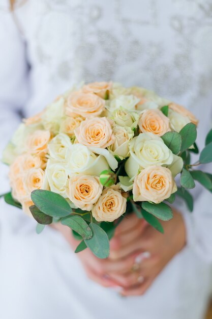 The bride is holding a wedding bouquet. beautiful wedding bouquet of roses. close up.