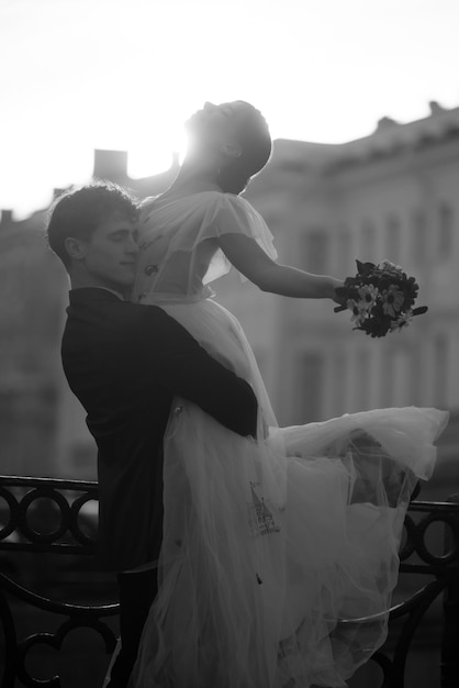 A bride is lifted up in the air by her groom.